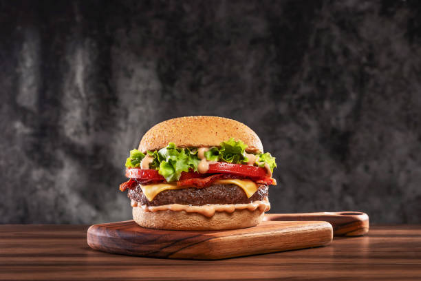 cheeseburger-with-tomato-and-lettuce-on-wooden-board.jpg